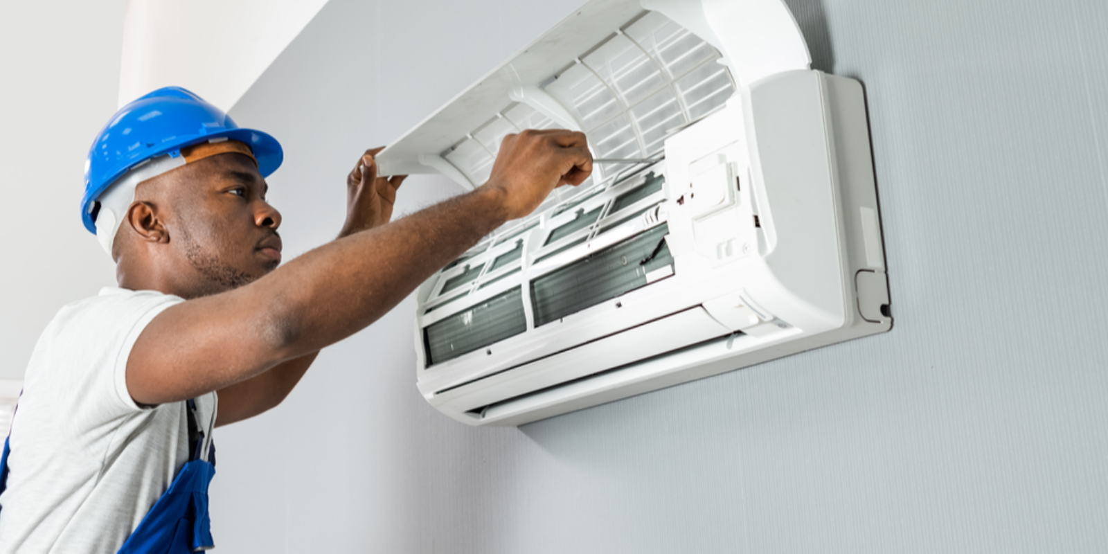 Professional AC technician repairing air conditioner